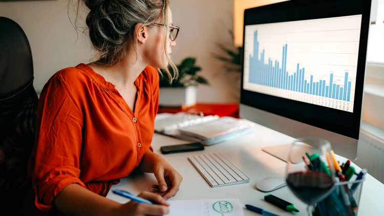 A woman in front of a computer analyzing electricity consumption data