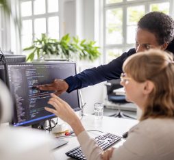 Deux femmes commentent du code à l'écran