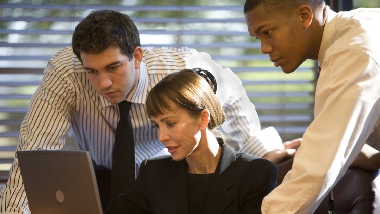Getty Images - A photo of three businesspeople working together in front of a laptop computer.