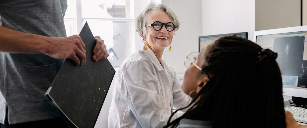 Research team working together in a laboratory, discussing data displayed on screens.
